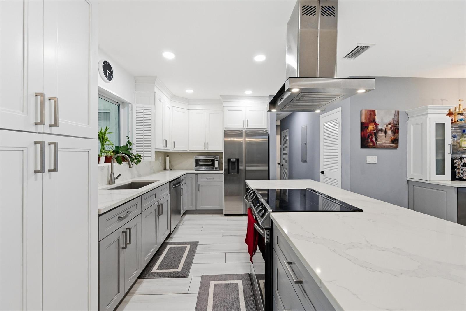 A dining area with a wooden table, gray walls, and a view of a patio — 141 SE 8th Street, Pompano Beach FL 33060, POMPANO BEACH, FL