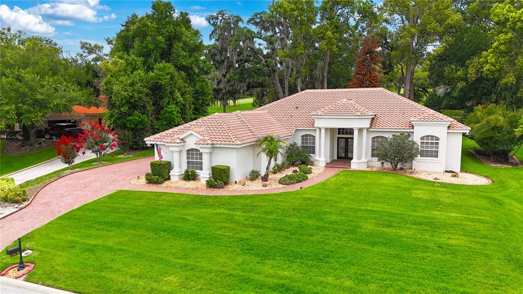 An aerial view shows a white single-story house with a tiled roof and green lawn — 12649 OAK HOLLOW COURT, DADE CITY, FL