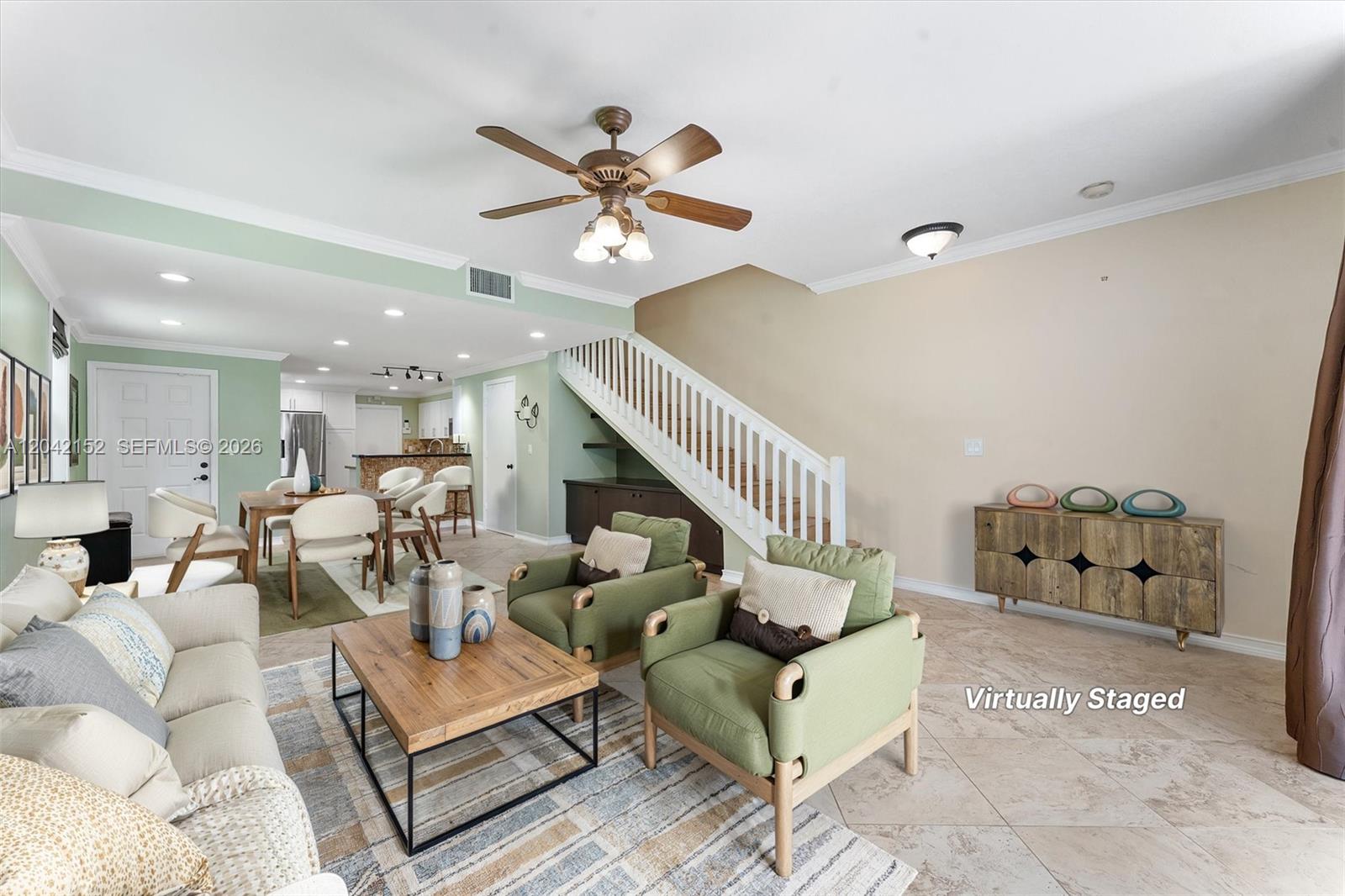 This living and dining area features tile flooring, a staircase, and green accent walls — 1552 Barcelona Way # 19, Weston FL 33327, WESTON, FL