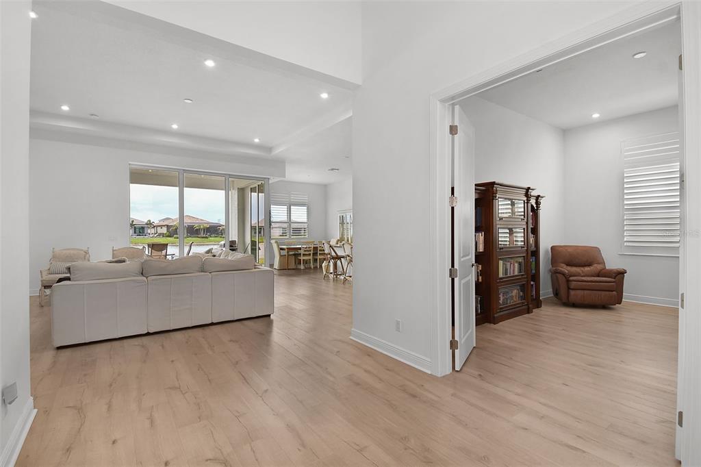 A bright living area with light wood floors leads to a separate room with French doors — 8472 SW CANTANTE WAY, PORT ST LUCIE, FL