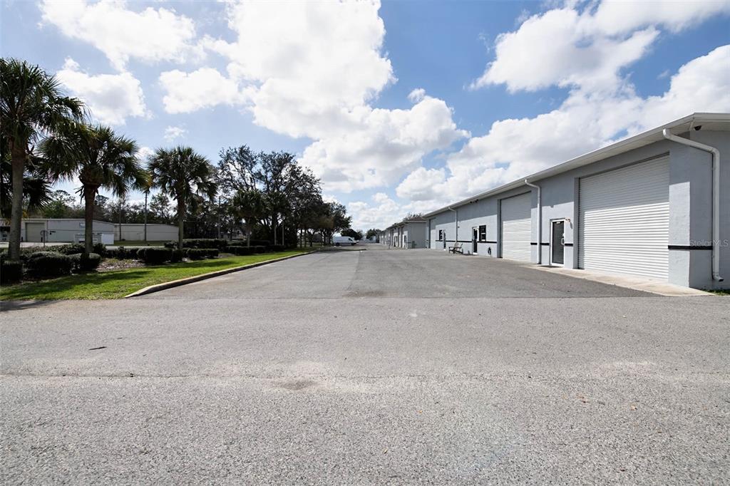 A paved parking lot sits in front of a row of industrial warehouse units — 3398 SW 74TH AVENUE, OCALA, FL