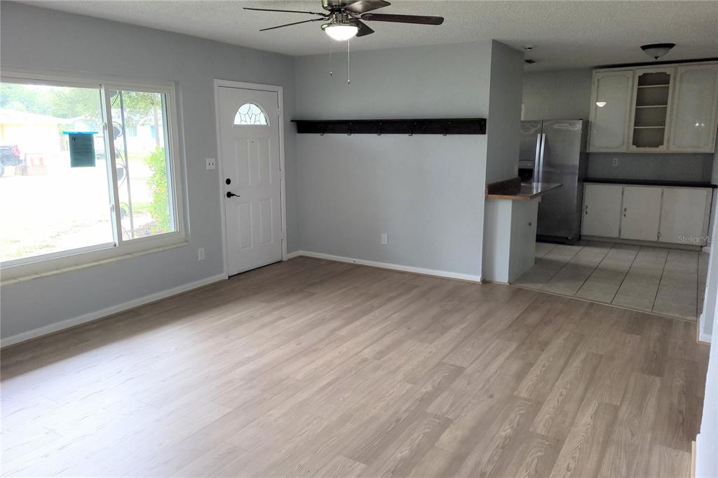 A single-story gray house with a screened-in porch sits on a large, grassy lot — 2928 BETTY DRIVE, SARASOTA, FL