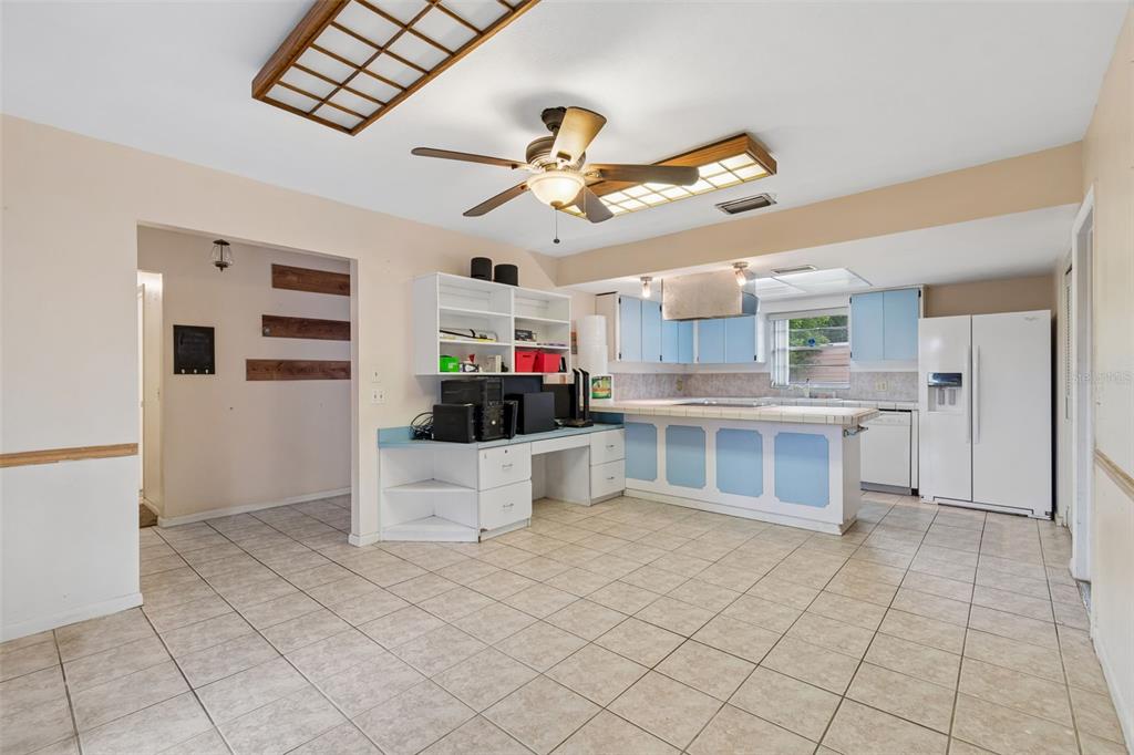 A kitchen with light blue cabinets, tile flooring, a desk area, and a ceiling fan — 418 DEWOLF ROAD, BRANDON, FL