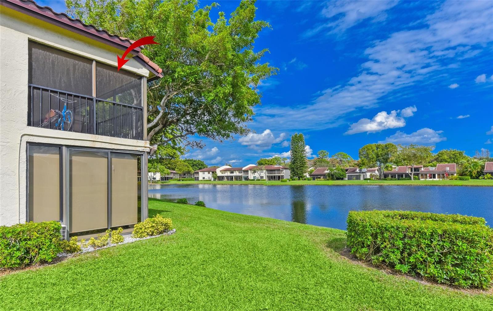 A two-story building with a screened-in balcony overlooking a lake and green lawn — 21827 Arriba Real # L, Boca Raton FL 33433, BOCA RATON, FL
