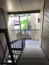 An outdoor staircase with metal railings leads down to a landing overlooking a parking area — 236 AFTON SQUARE UNIT 306, ALTAMONTE SPRINGS, FL