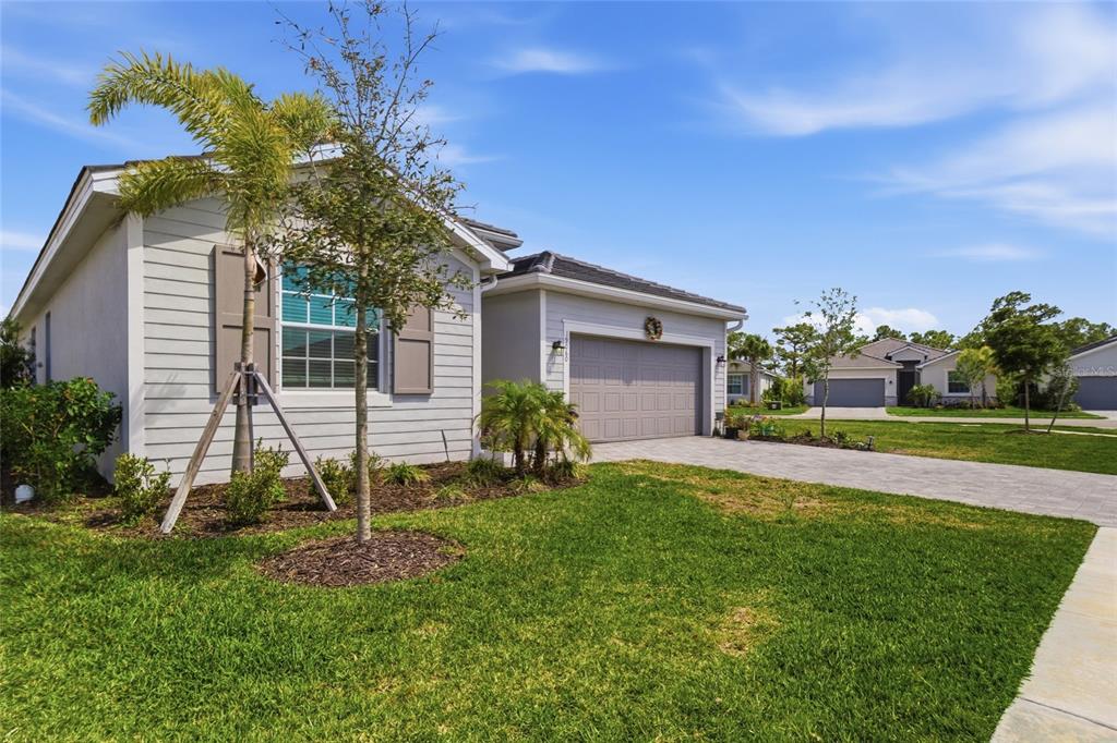 A single-story house with light gray siding, a two-car garage, and a paved driveway — 19060 CABERNET COURT, VENICE, FL