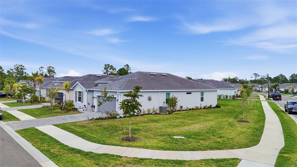 A single-story house with a gray tile roof, garage, and a sidewalk in front — 19060 CABERNET COURT, VENICE, FL