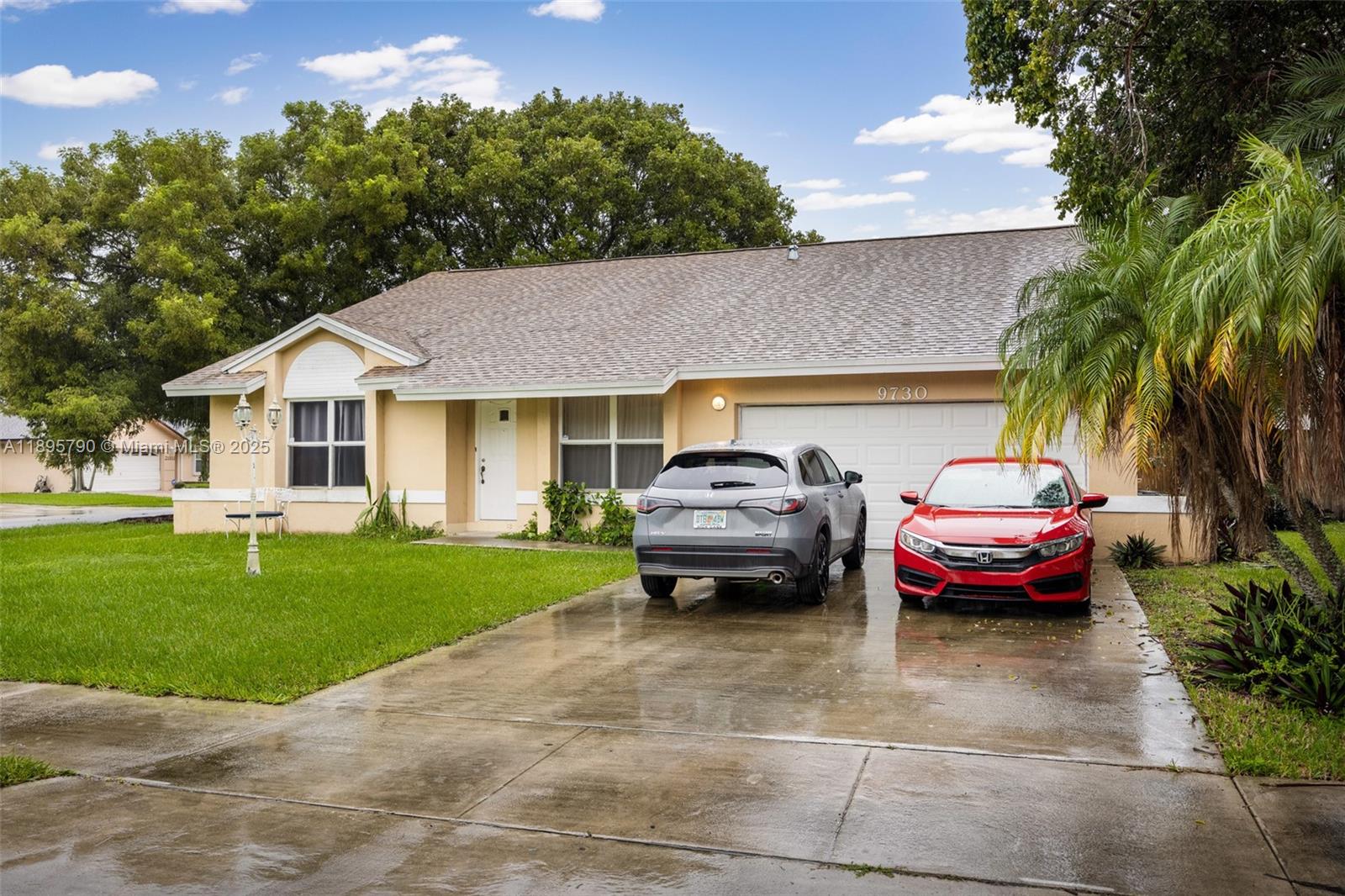 A single-story house with a two-car garage and a driveway featuring two parked cars — 9730 SW 219th St, Cutler Bay FL 33190, CUTLER BAY, FL