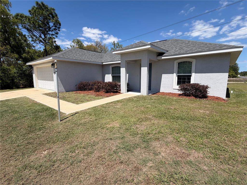 A single-story house with a gray stucco exterior, a gray shingled roof, and a garage — 15369 SW 65TH TERRACE ROAD, OCALA, FL