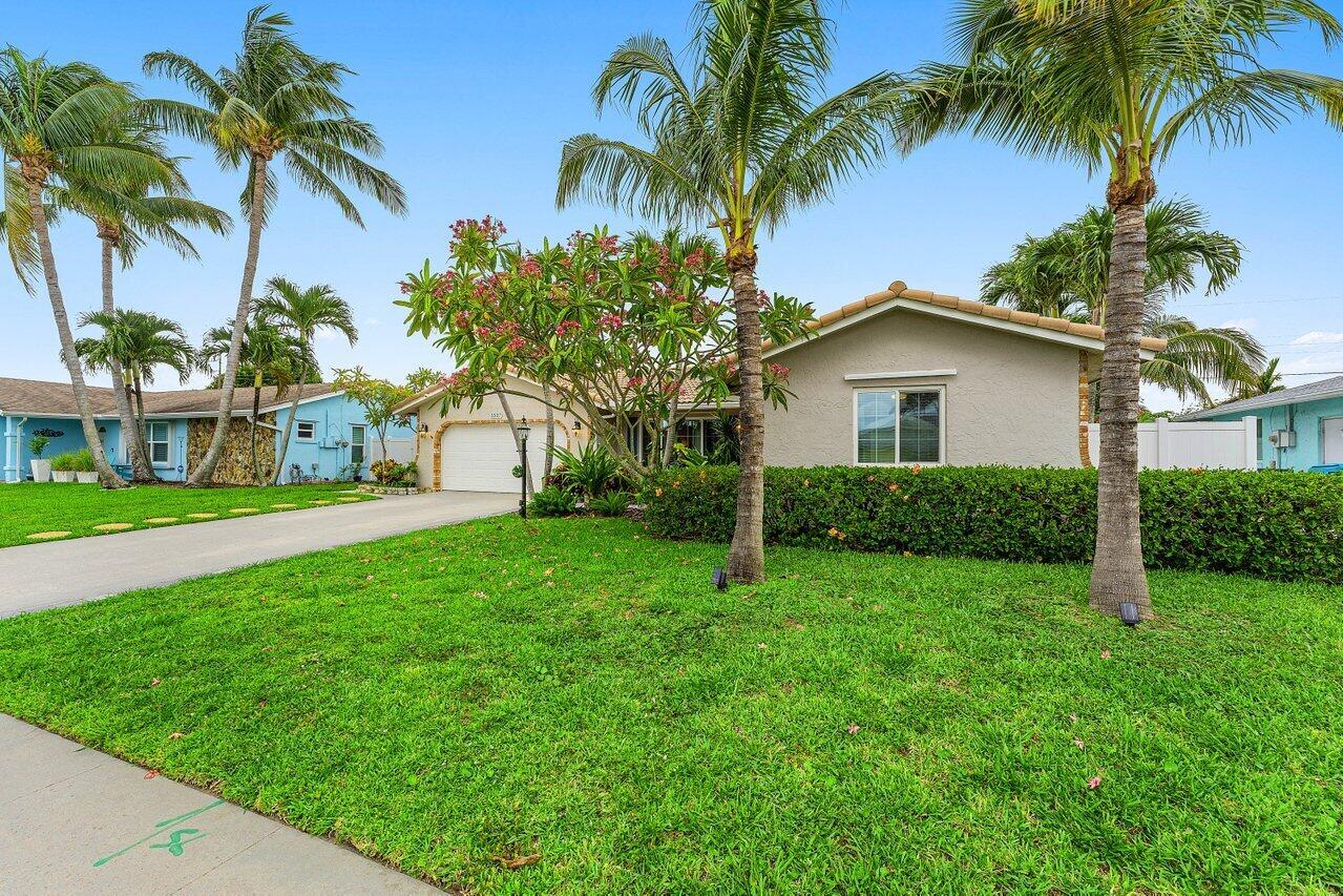 A single-story house with a beige exterior, a two-car garage, and palm trees in front — 2527 SW 12th Street, Boynton Beach FL 33426, BOYNTON BEACH, FL