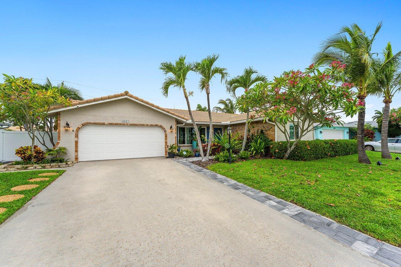 A single-story house with a white garage door, palm trees, and a paved driveway — 2527 SW 12th Street, Boynton Beach FL 33426, BOYNTON BEACH, FL