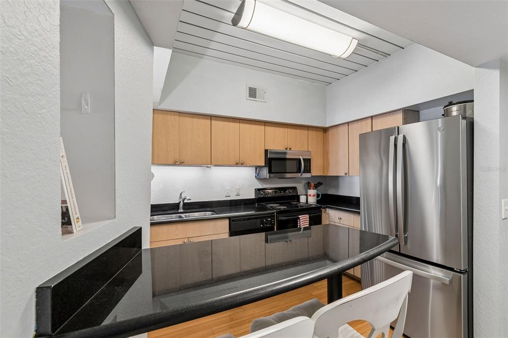 A dining area with a wooden bench seat and a living room with a sofa — 2331 W HORATIO STREET UNIT 625, TAMPA, FL