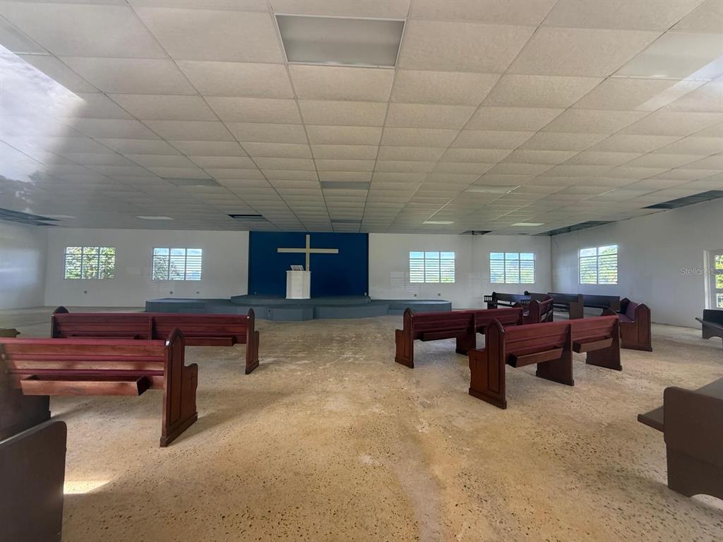 An interior view of a church sanctuary featuring wooden pews, a stage, and a cross — 111 CARR 111 R 602 KM 1.2 INT. BO ANGELES, ANGELES, PR