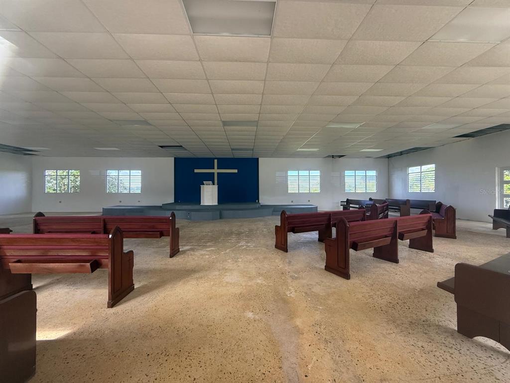 A church sanctuary features rows of wooden pews, a raised altar with a cross, and tile flooring — 111 CARR 111 R 602 KM 1.2 INT. BO ANGELES, ANGELES, PR