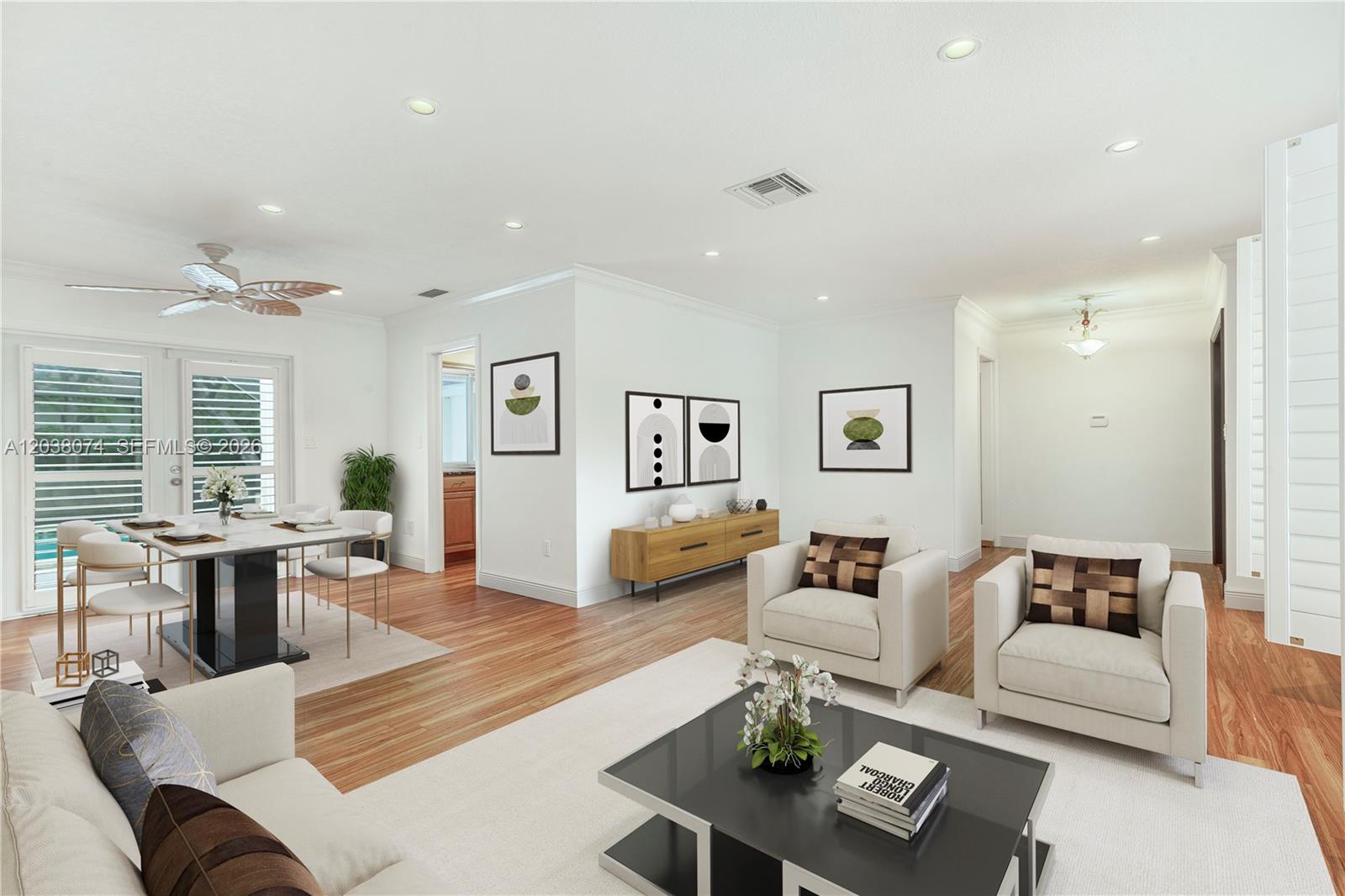 A bright, open-concept living and dining area features white walls, wood flooring, and modern furniture — 7715 SW 122nd St, Pinecrest FL 33156, PINECREST, FL