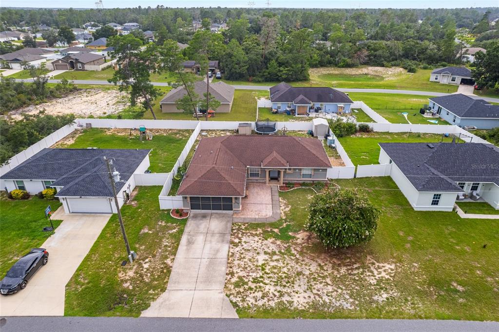 An aerial view shows a suburban house with a brown roof and a concrete driveway — 16900 SW 42ND AVENUE ROAD, OCALA, FL