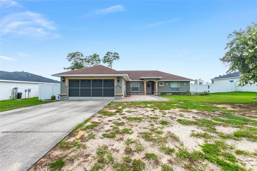 A single-story house with a concrete driveway, a two-car garage, and a paved front entryway — 16900 SW 42ND AVENUE ROAD, OCALA, FL