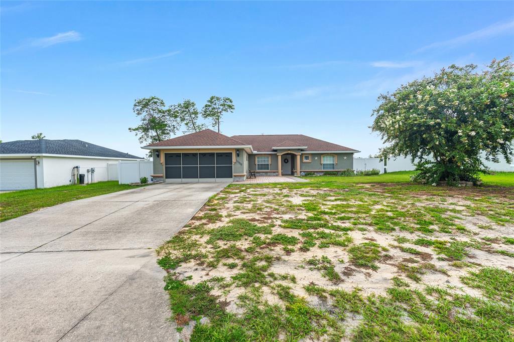 A single-story house with a brown roof, garage, and a large, patchy grass front yard — 16900 SW 42ND AVENUE ROAD, OCALA, FL