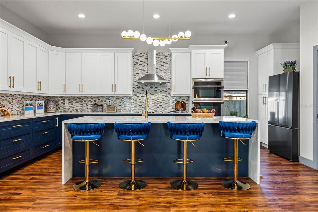 A dining area with a glass table and chandelier opens into a bright living room — 6325 11TH AVENUE S, GULFPORT, FL