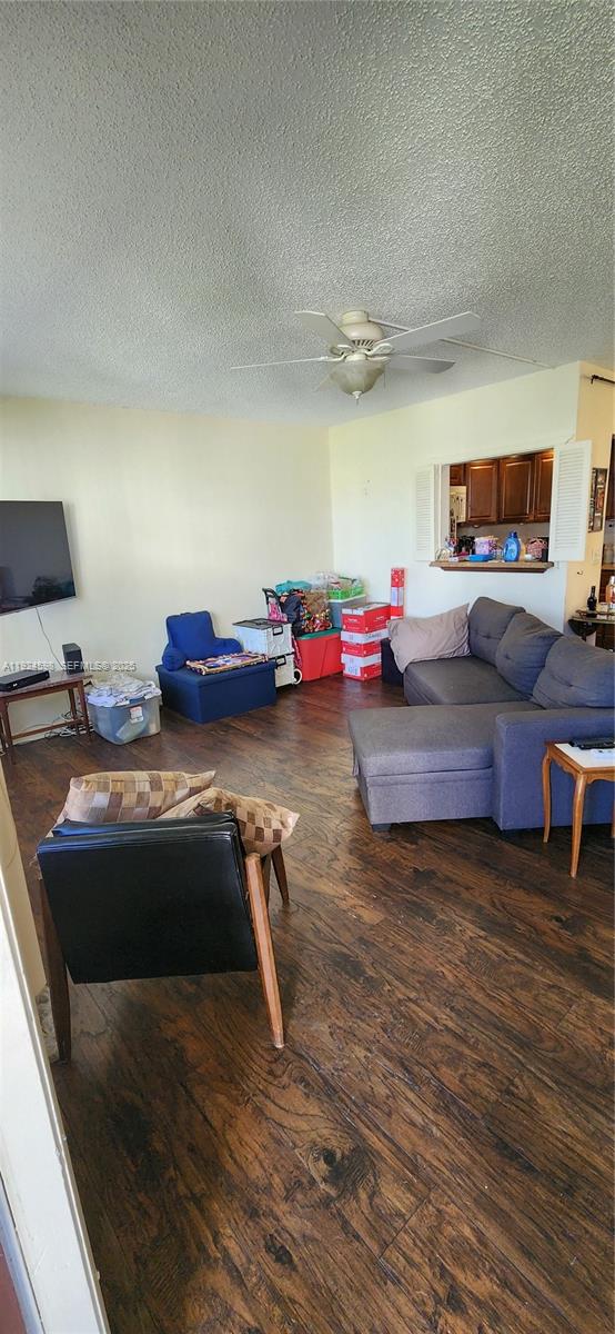 A living room with dark wood flooring, a grey sectional sofa, and a ceiling fan — 191 E Preston  E # 191, Boca Raton FL 33434, BOCA RATON, FL