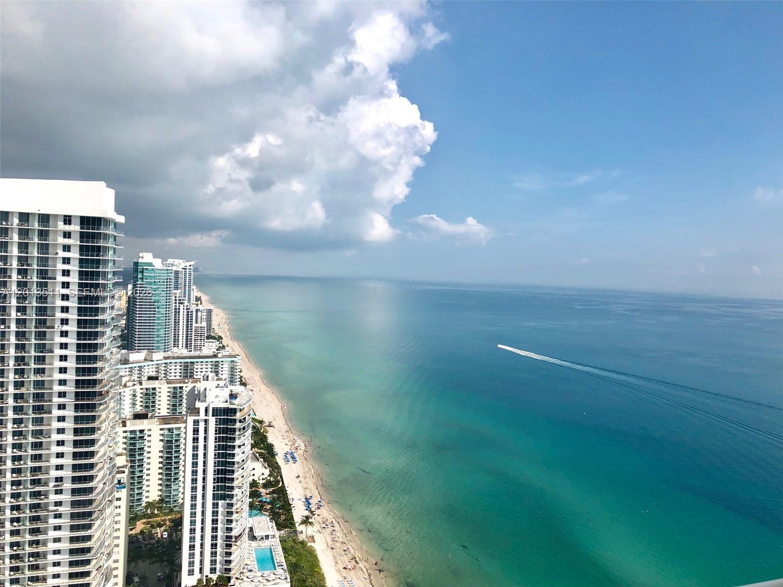 An aerial view of a coastal city with high-rise buildings along a sandy beach — HALLANDALE BEACH, FL