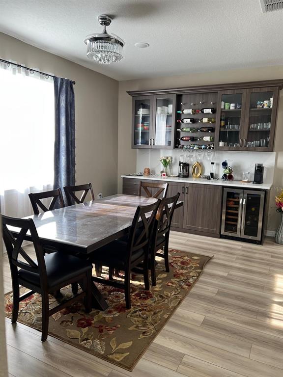 A dining room features a dark wood table, chairs, and a built-in wet bar — 3900 ALMOND BROOK BOULEVARD, LAND O LAKES, FL