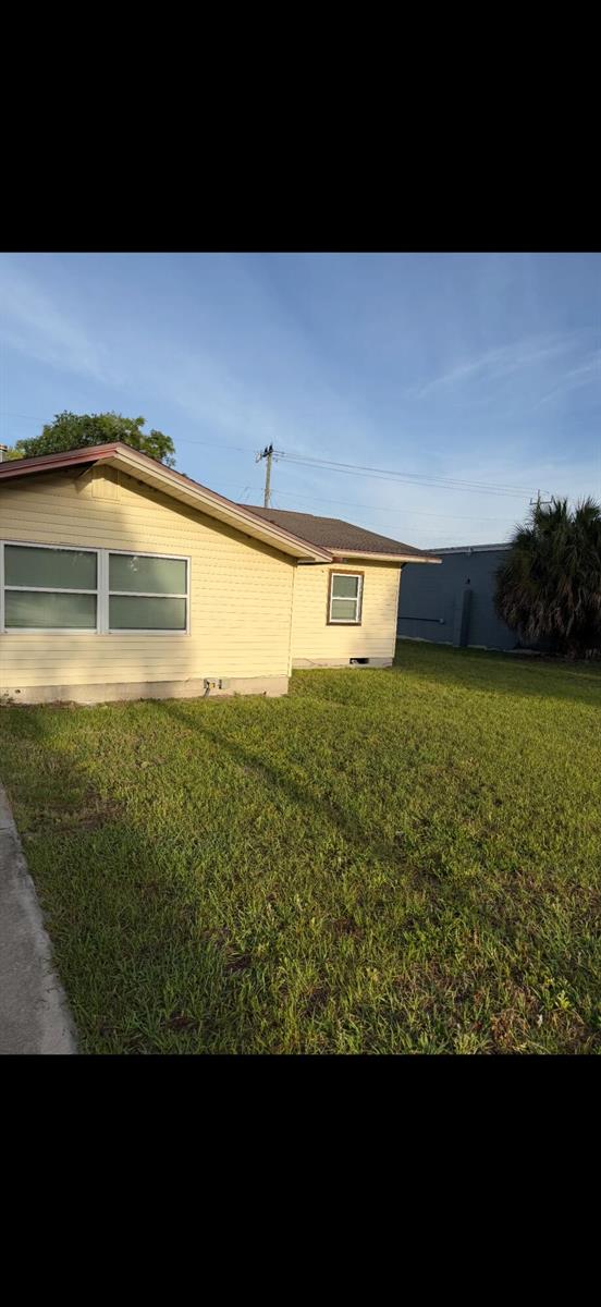 A yellow house with horizontal siding and a brown roof sits on a grassy lawn — 1011 S Palm Avenue, Palatka FL 32177, PALATKA, FL