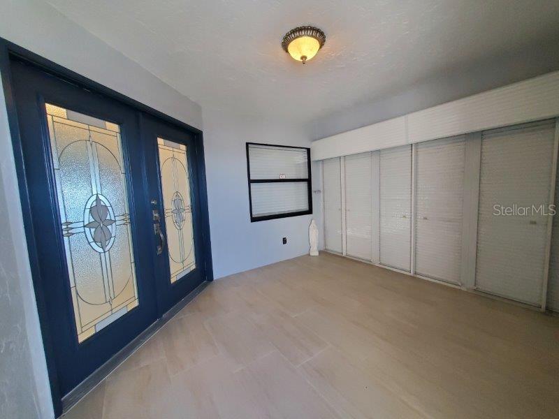 An entryway features a dark blue double door with glass panels and light-colored tile flooring — 1600 W MARION AVENUE UNIT 232, PUNTA GORDA, FL