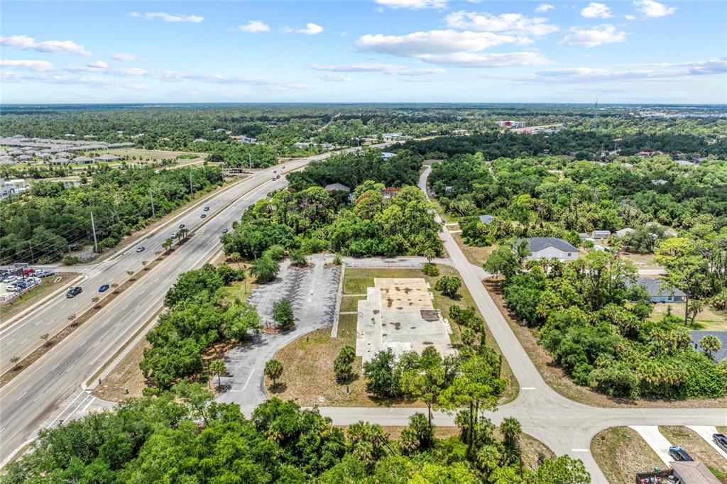 An aerial view shows a vacant concrete building foundation next to a paved parking lot — 640 TAMIAMI TRAIL, PORT CHARLOTTE, FL