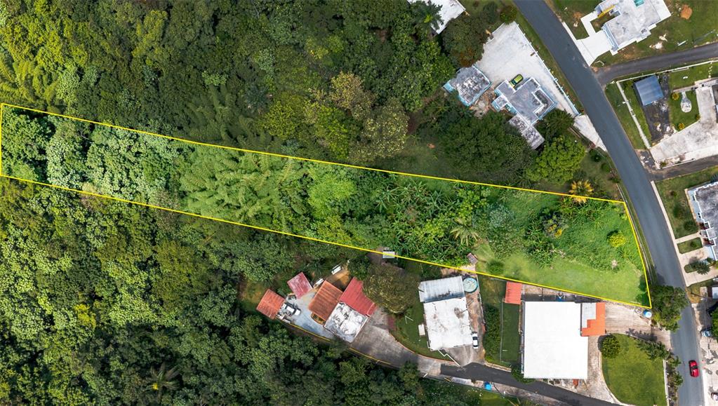An aerial view shows a rectangular plot of land outlined in yellow near residential houses — Cuchillas Ward STATE ROAD 618 KM1.6, MOROVIS, PR