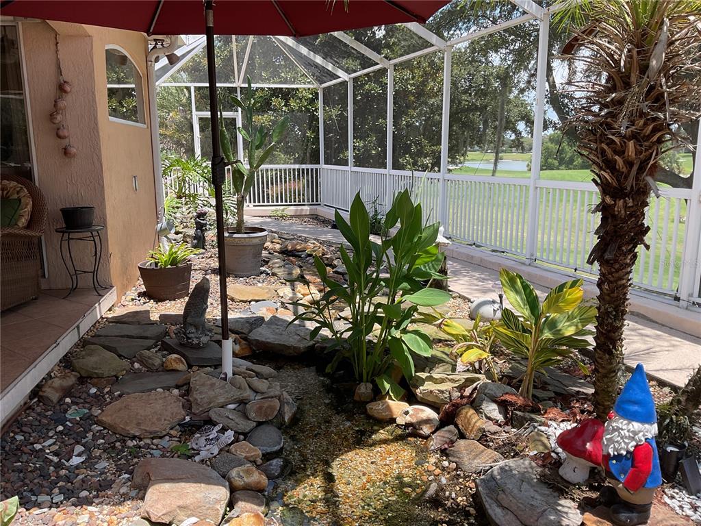 A covered patio features wicker furniture, a ceiling fan, and views of a golf course — 17116 SE 79TH MCLAWREN TERRACE, THE VILLAGES, FL