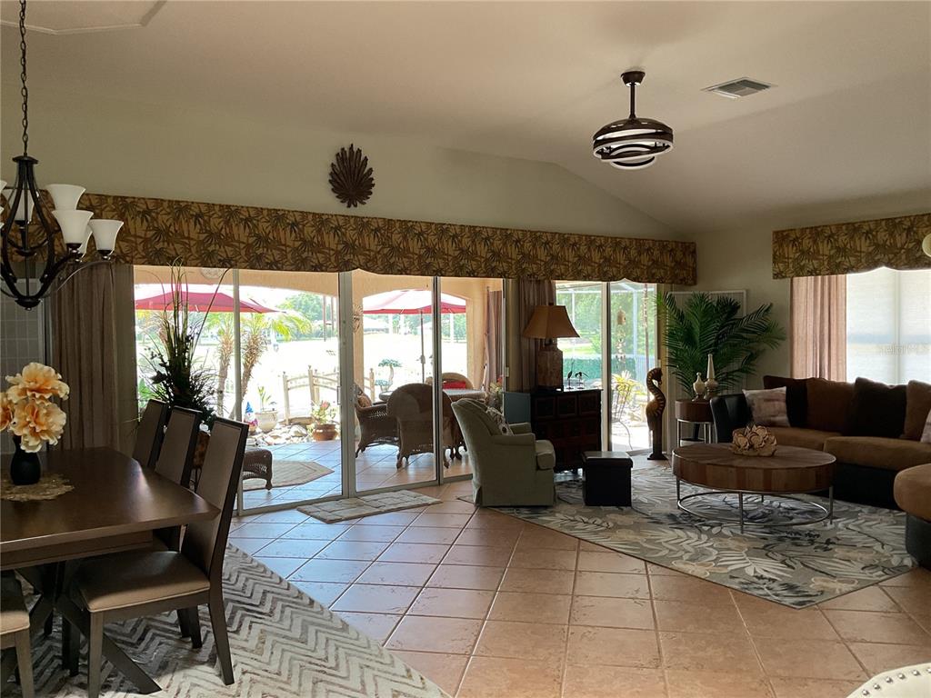 A kitchen with light gray cabinets, a wooden butcher block island, and a dining area — 17116 SE 79TH MCLAWREN TERRACE, THE VILLAGES, FL