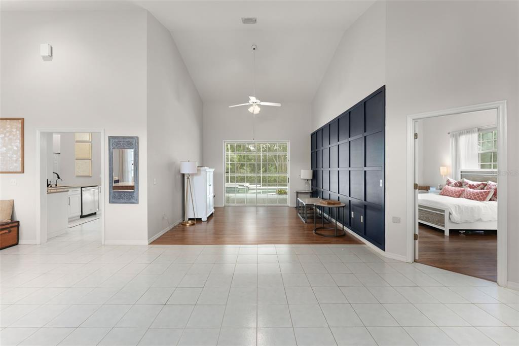 A living area with white tile floors, a dark blue accent wall, and sliding glass doors — 551 WHEATSTONE PLACE, ORLANDO, FL