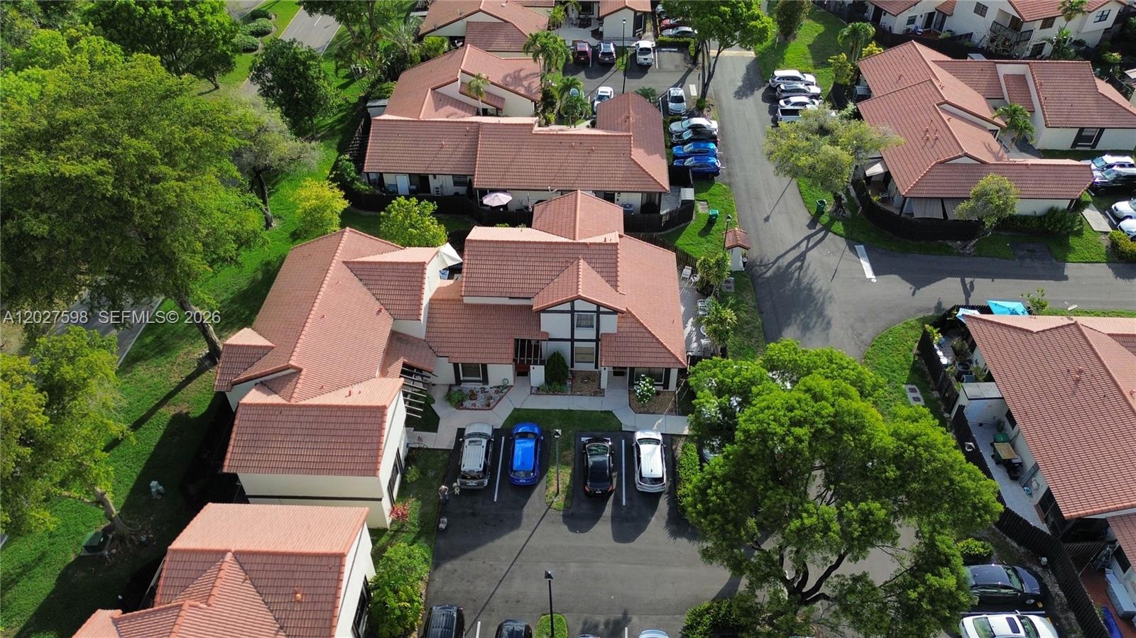 An aerial view shows a residential complex with terracotta-tiled roofs and a parking lot — 14950 SW 49th Ln # 7C, Miami FL 33185, MIAMI, FL