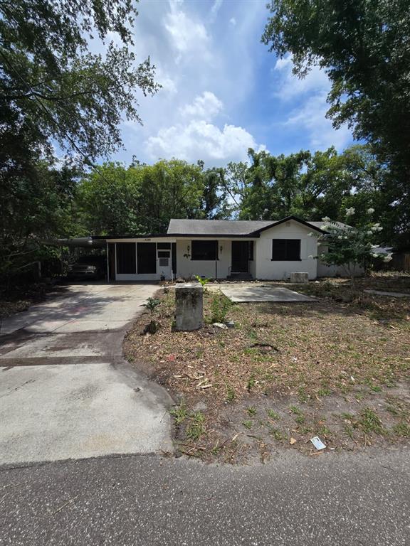 A single-story house with a white exterior, a covered carport, and a concrete driveway — 3328 AVENUE T NW, WINTER HAVEN, FL
