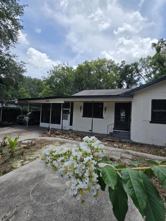 A single-story house with a white stucco exterior, a carport, and a front porch — 3328 AVENUE T NW, WINTER HAVEN, FL