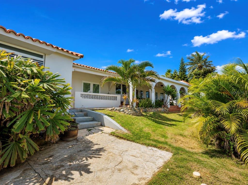 A white house with a red tile roof features a covered patio and palm trees — KENNEDY  ST. BO. MAMEYAL , , PR 006 LOT 106, DORADO, PR