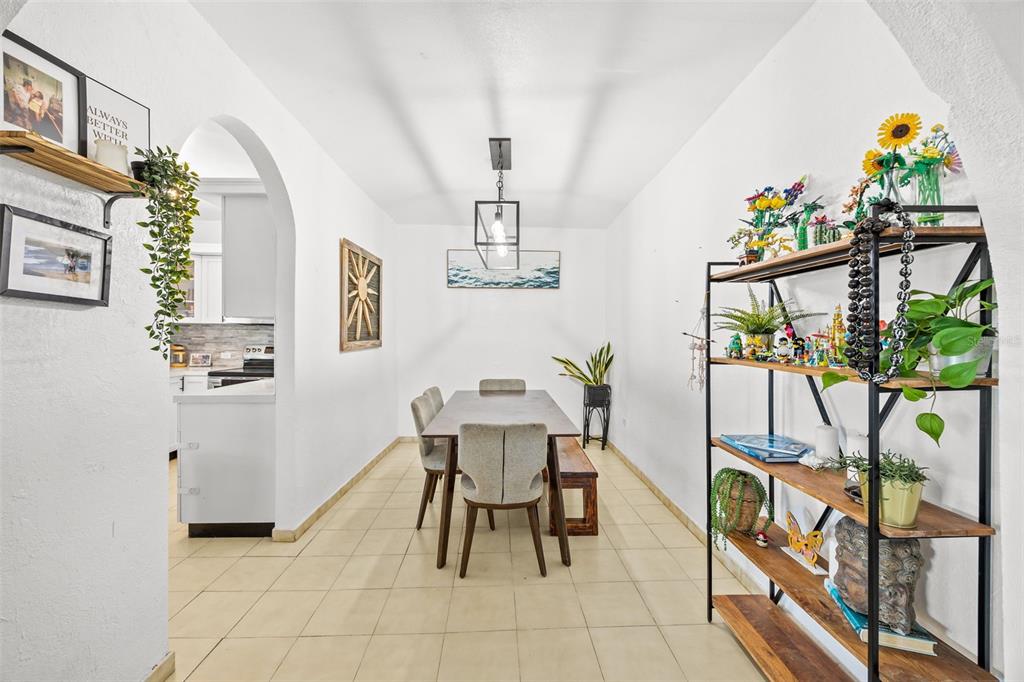 A dining room features a rectangular table, chairs, a metal shelving unit, and tiled floors — KENNEDY  ST. BO. MAMEYAL , , PR 006 LOT 106, DORADO, PR