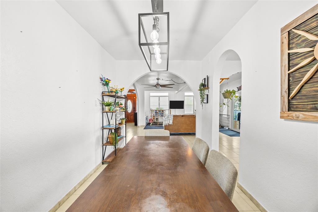 A dining room features a long wooden table, a modern pendant light, and arched doorways — KENNEDY  ST. BO. MAMEYAL , , PR 006 LOT 106, DORADO, PR