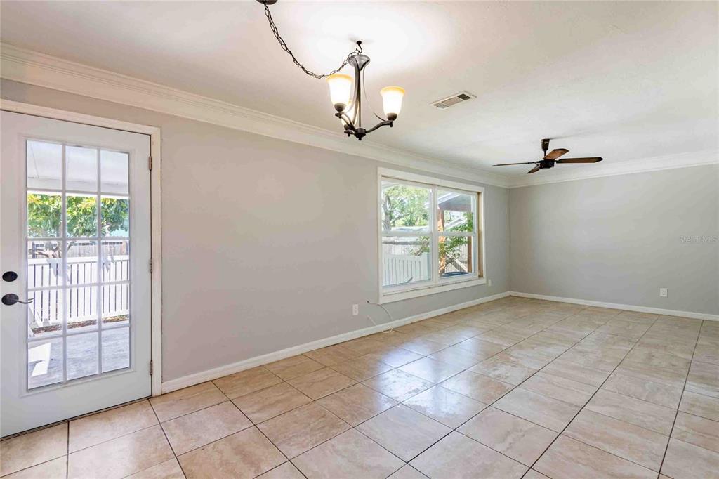 A room with light gray walls, tile flooring, a ceiling fan, and a glass-paneled door — 2741 37TH STREET S, ST PETERSBURG, FL