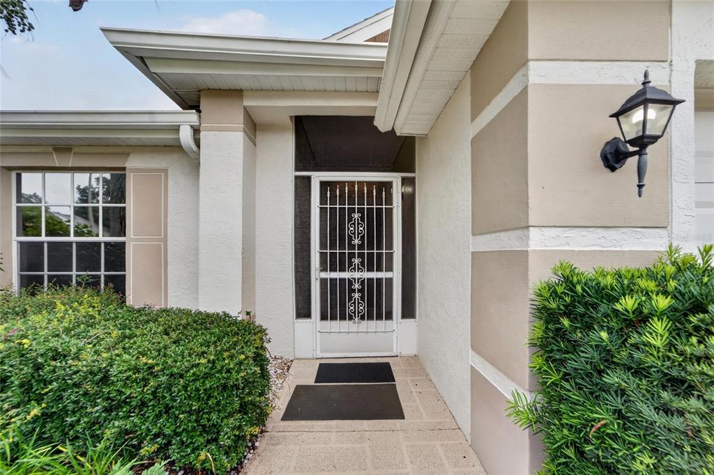 The exterior of a house features a front door with a white security screen door — 1023 MCDANIEL STREET UNIT 139, SUN CITY CENTER, FL