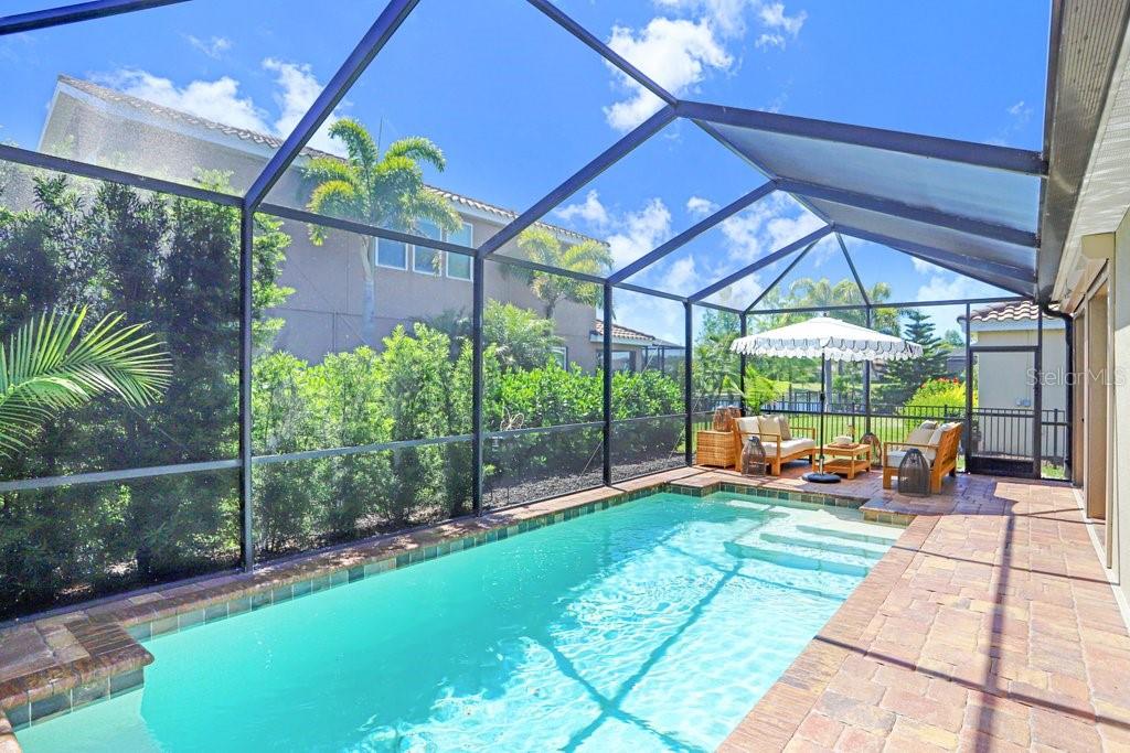 A single-story house with tan siding, a tiled roof, and a paved driveway — 2807 ORIOLE DRIVE, SARASOTA, FL