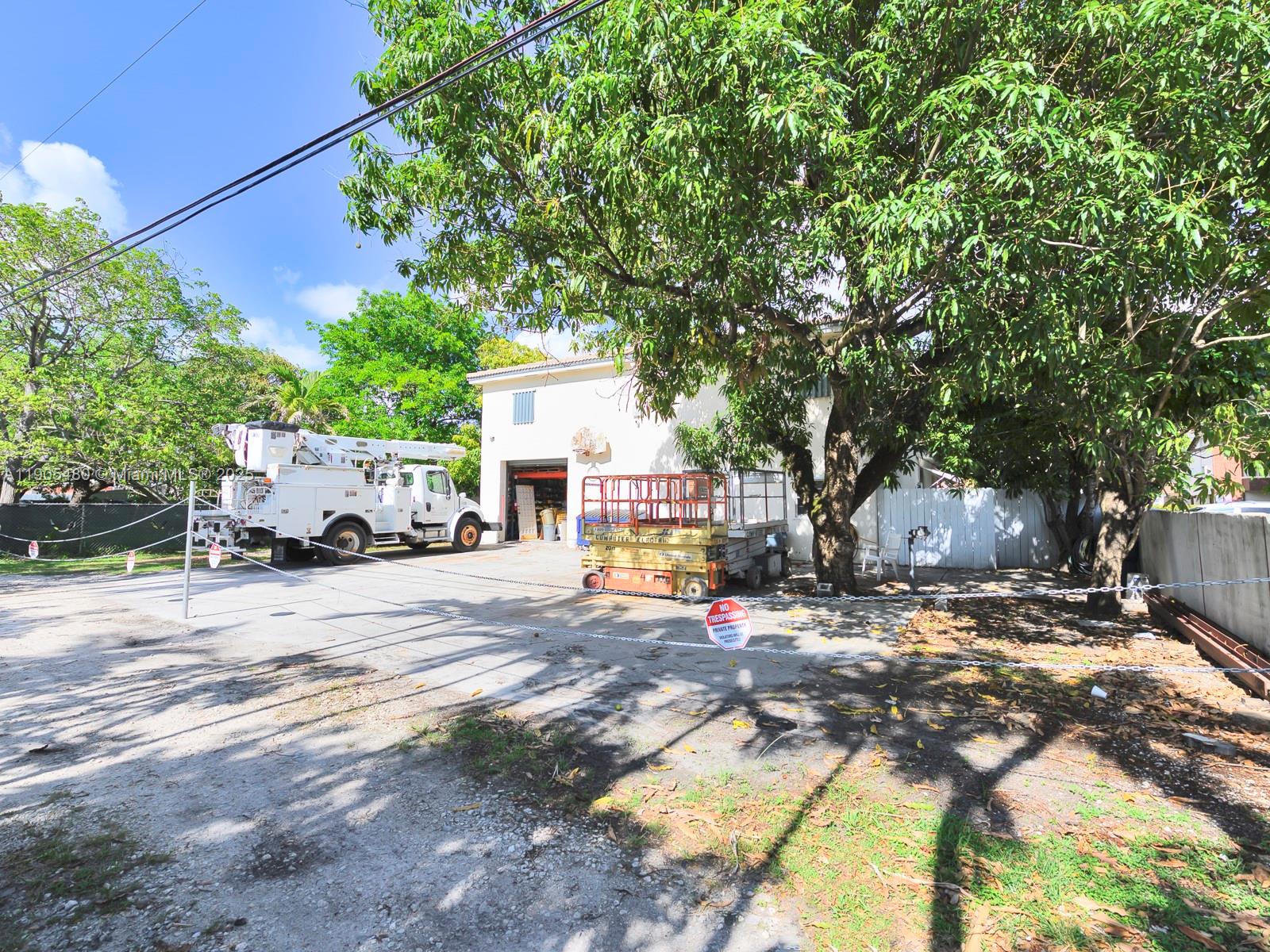 A white utility truck and a yellow scissor lift are parked in front of a building — 660 Miller Dr, Miami Springs FL 33166, MIAMI SPRINGS, FL