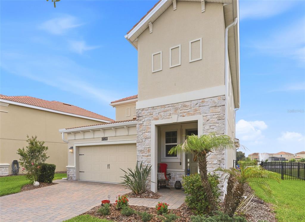 A covered patio features a sectional sofa, a refrigerator, a hot tub, and a television — 8728 PACIFIC DUNES DRIVE, DAVENPORT, FL