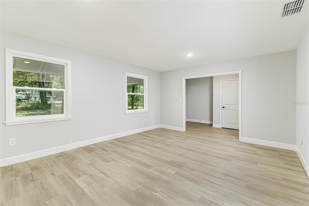 An empty room with light gray walls, wood-look flooring, and two windows — 7520 HAVENWOOD DRIVE, LAKELAND, FL