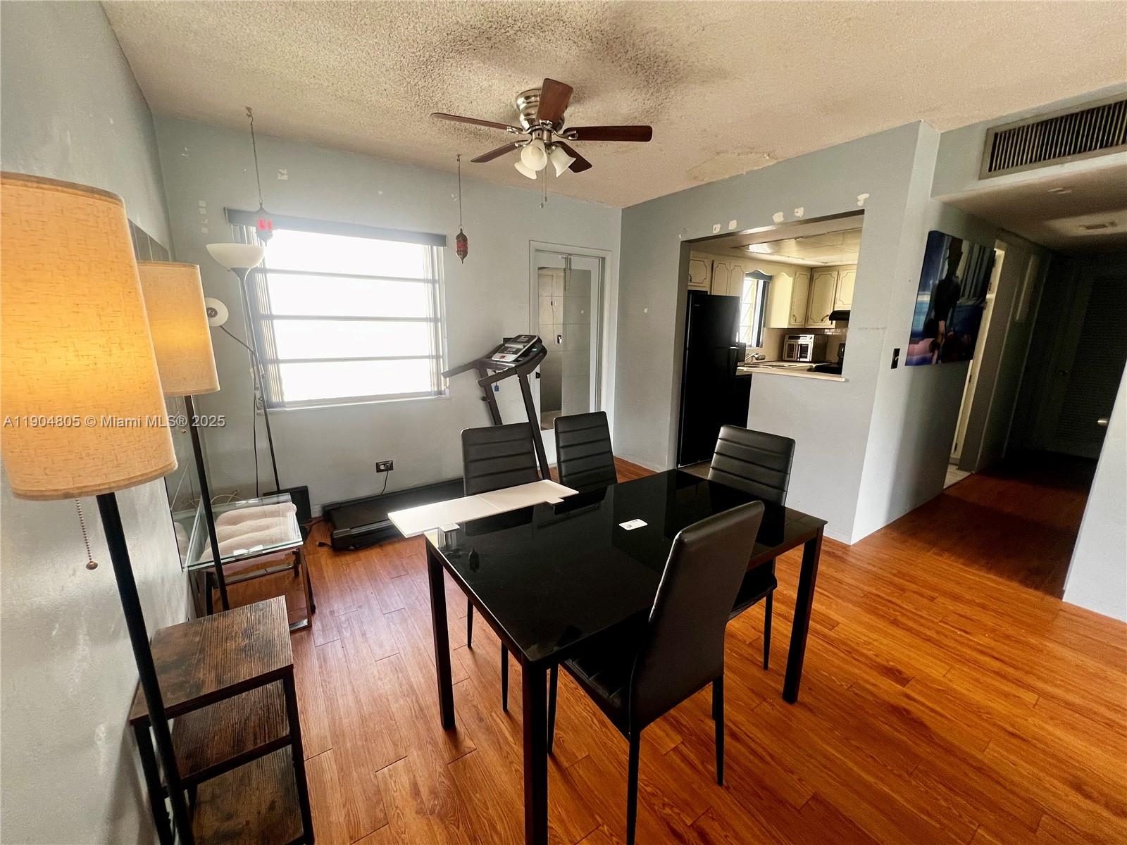 A dining area features a black table, four chairs, wood-look flooring, and a ceiling fan — 1501 Arthur St # 7, Hollywood FL 33020, HOLLYWOOD, FL