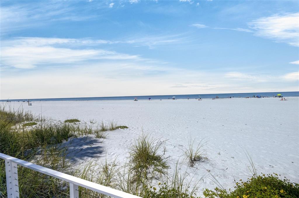 A view of a wide, white sand beach from a balcony with a white railing — 17960 GULF BLVD UNIT 108, REDINGTON SHORES, FL