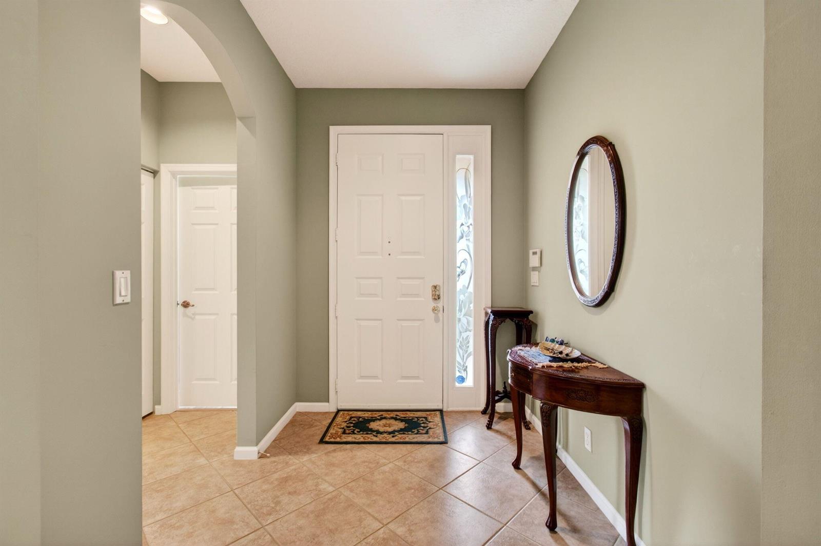 An entryway features sage green walls, tile flooring, a white front door, and a wooden console — 6453 Emerald Breeze Way, Boynton Beach FL 33437, BOYNTON BEACH, FL