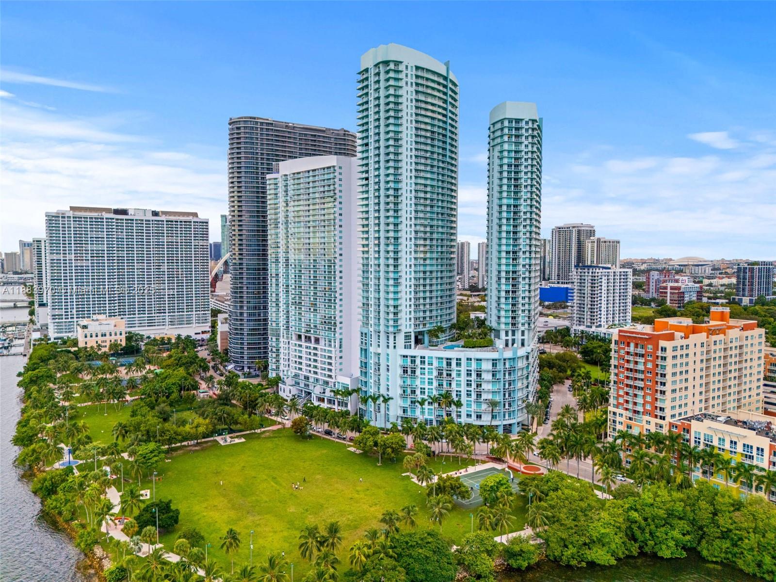 An aerial view shows several high-rise apartment buildings situated next to a large public park — 1900 N Bayshore Dr # 4018, Miami FL 33132, MIAMI, FL