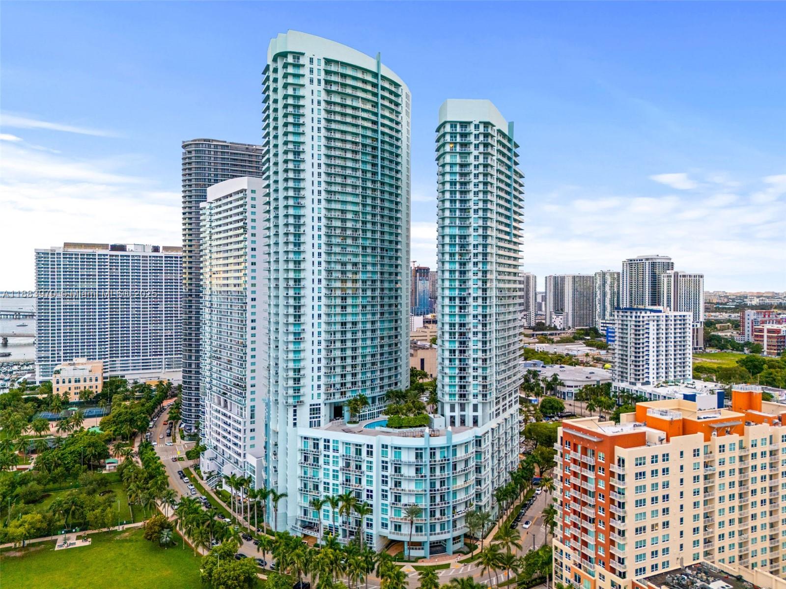 An aerial view of two tall, light-blue residential towers surrounded by other high-rise buildings — 1900 N Bayshore Dr # 4018, Miami FL 33132, MIAMI, FL